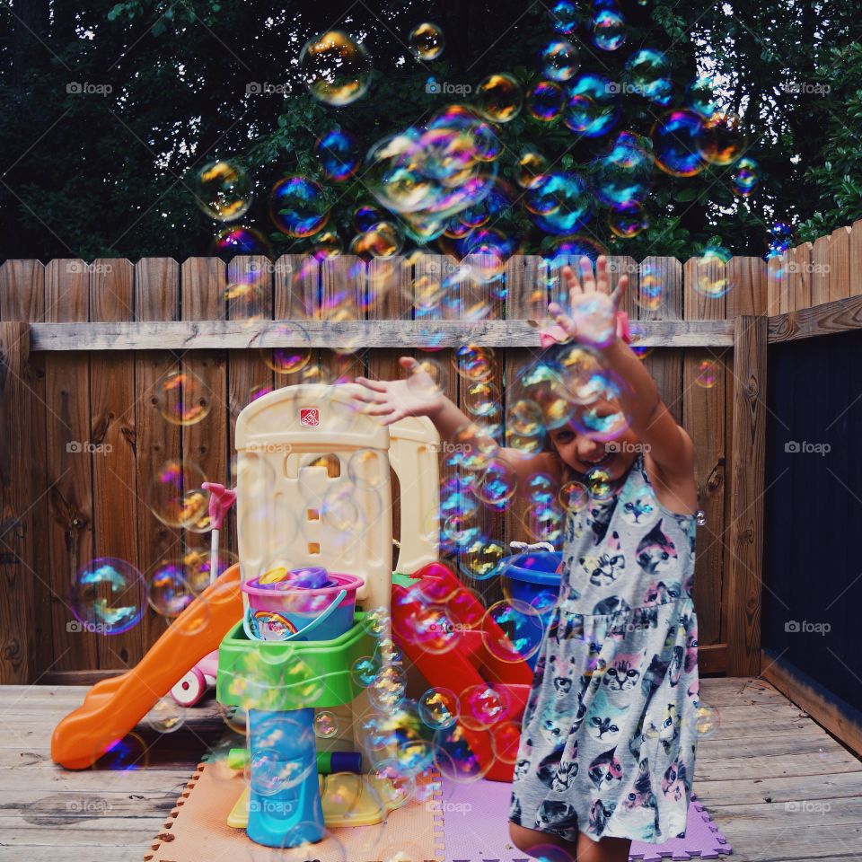 Little girl enjoying in soap bubble