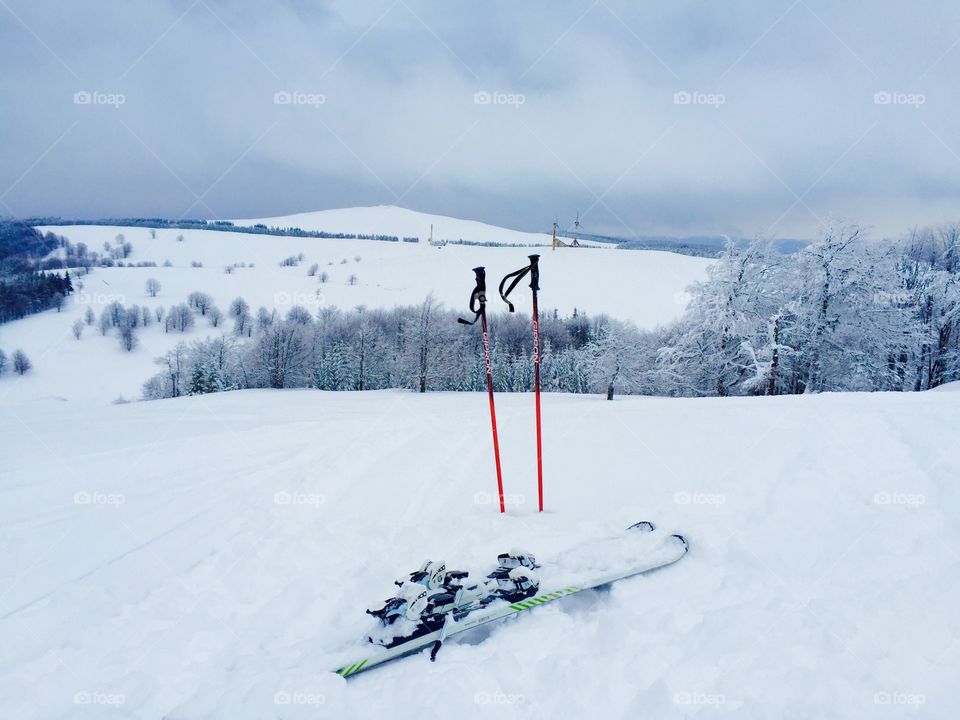 Skiis and gloves with winter landscape 