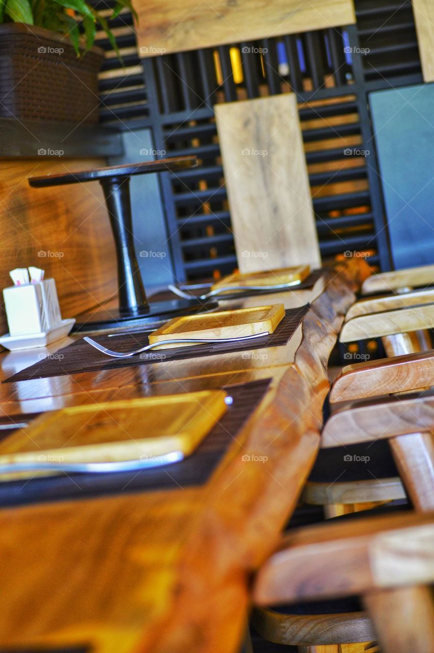 cafe interior in loft style with paintings and wooden interior items . bar counter made of service t wooden plates.