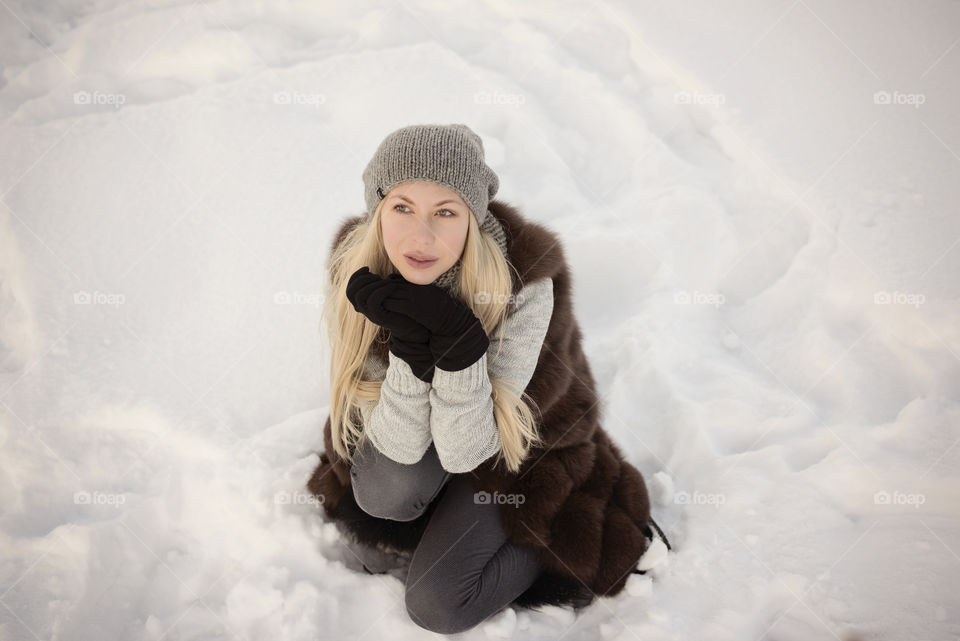 Woman sitting on snowy landscape