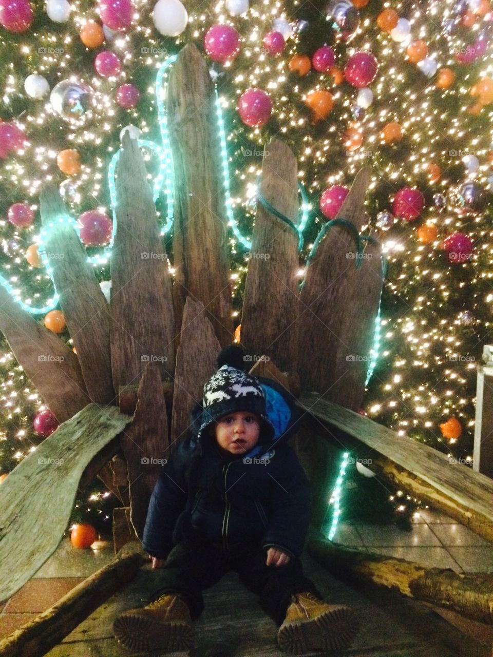 Cute boy sitting around illuminated background