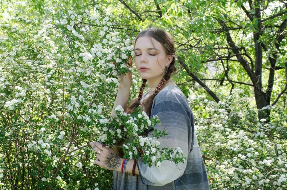 Portrait of Young Girl on Background of Flowers