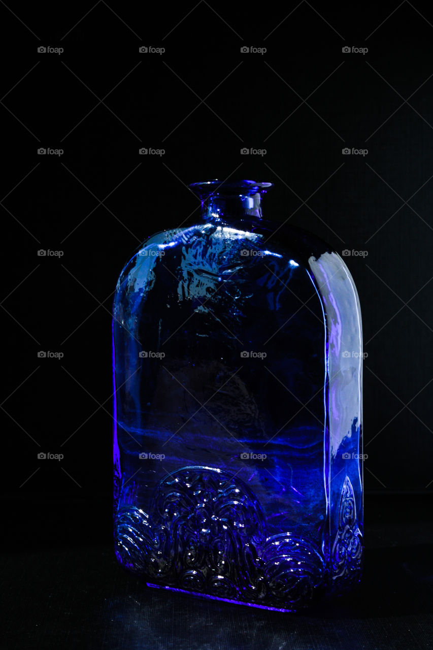 Blue bottle in black background 