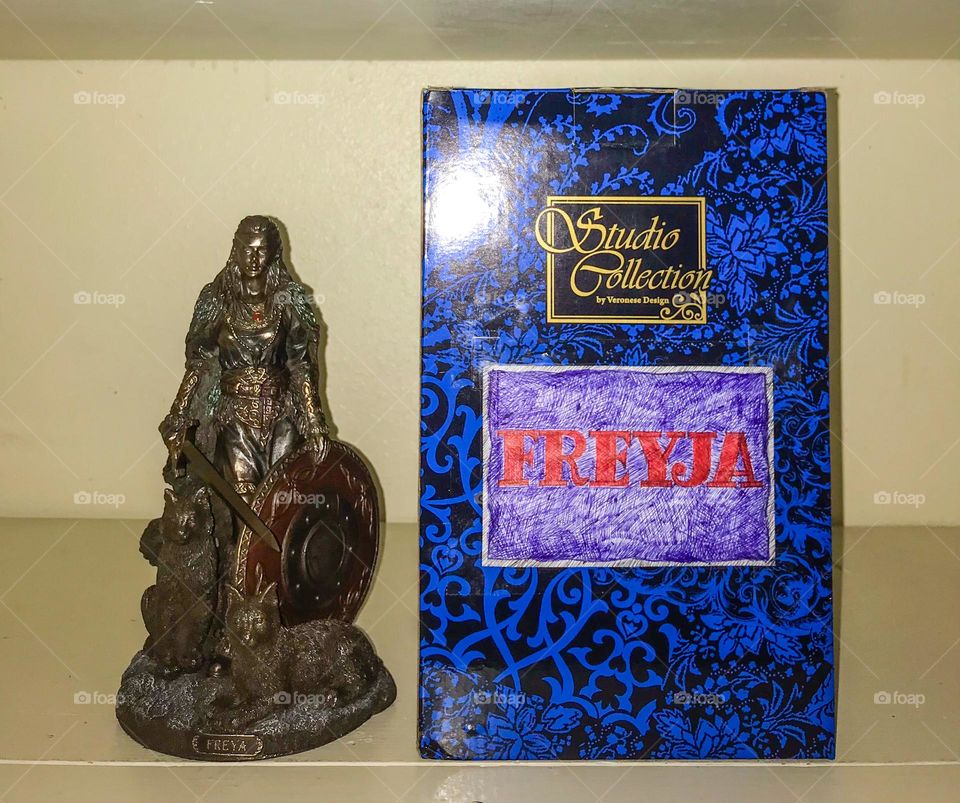 A statue of shieldmaiden Freyja with its protective box. This Norse martial curio originally came in the box which is now somewhat repurposed as what was mentioned to contain the statue when it is not on display.