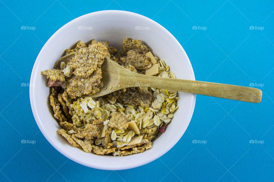 cereals for breakfast. crunchy cereals in white bowl.and wooden spoon for healthy breakfast