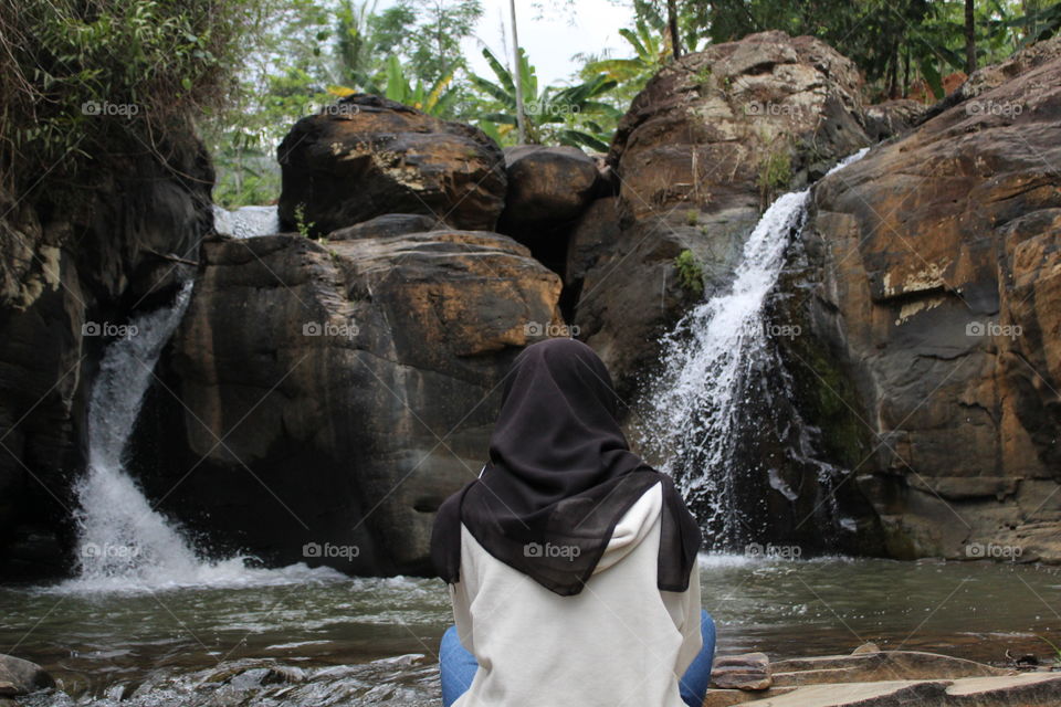 a girl in the midle of waterfall