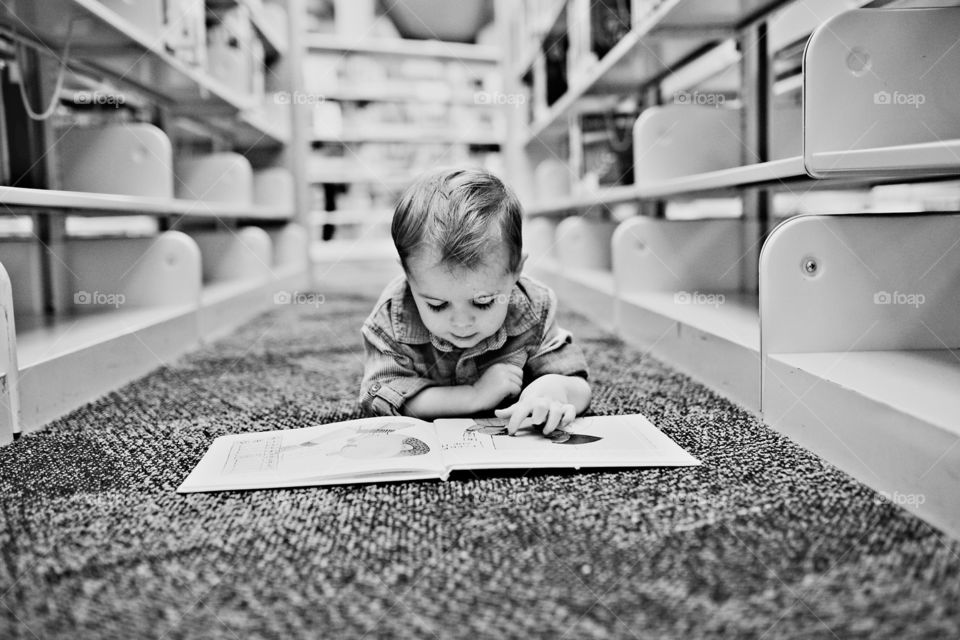 Boy lying on the floor reading a book