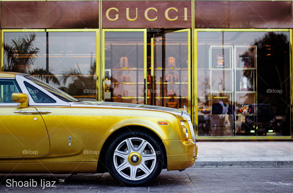 Gold Rolls Royce Phantom Drop head Coupe infront of GUCCI.
Gold Theme.