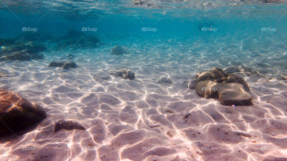 High angle view of rocks and sand in sea