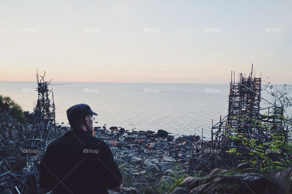 Man looking out on Lars Vilks artwork in skåne sweden