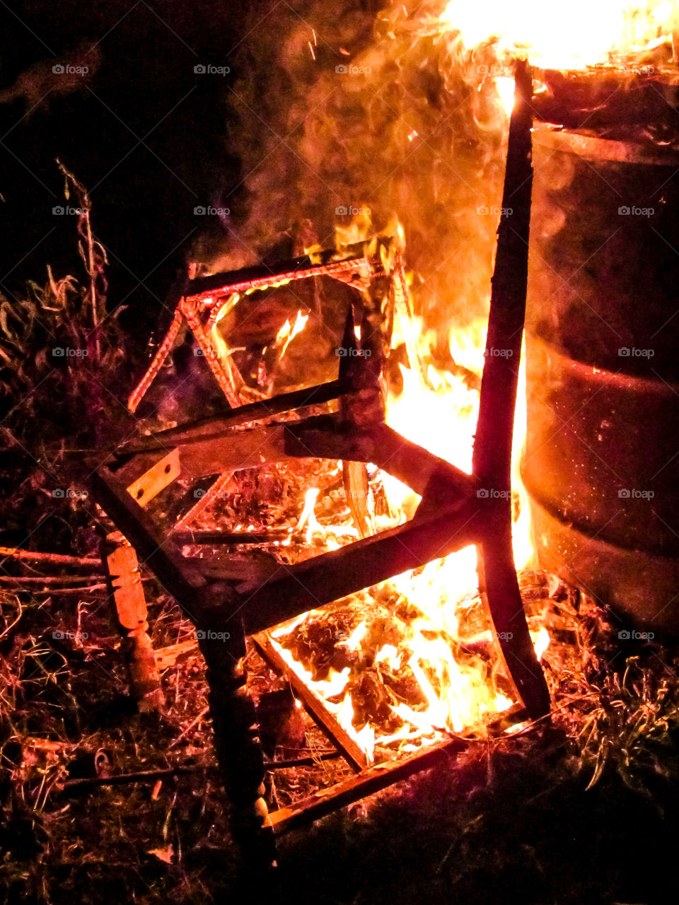 wooden chair on fire at night outdoors