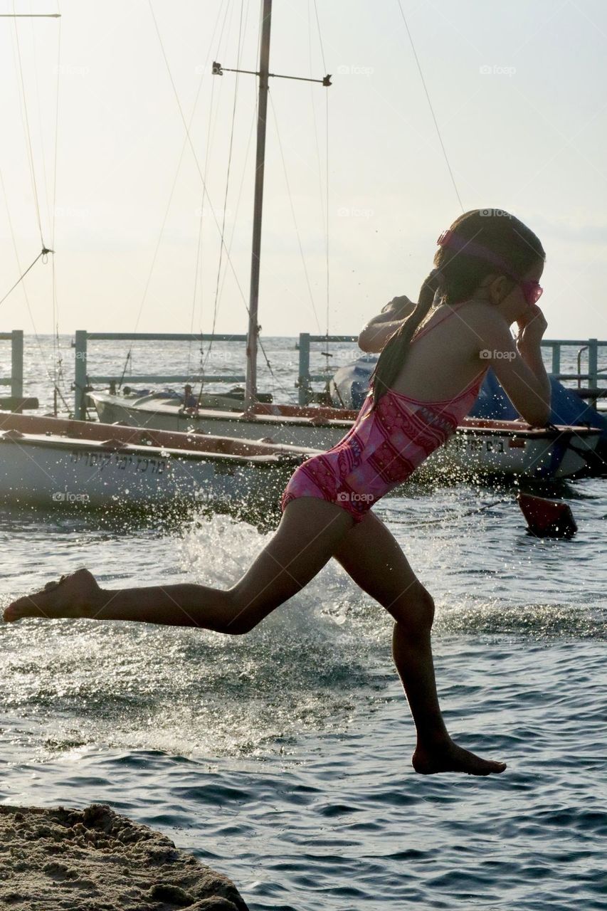 Girl jumping into the water