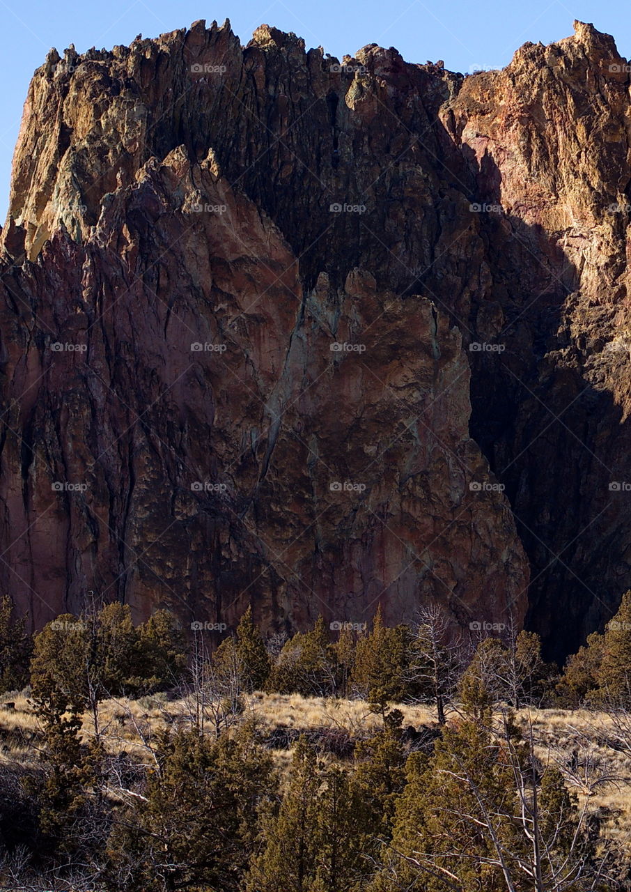 A giant round and open jagged and textured cliff at Smith Rock State Park in Central Oregon on a sunny day. 
