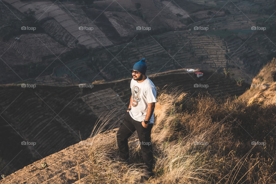 A man standing alone on the beautiful hills in the morning, enjoying the view around