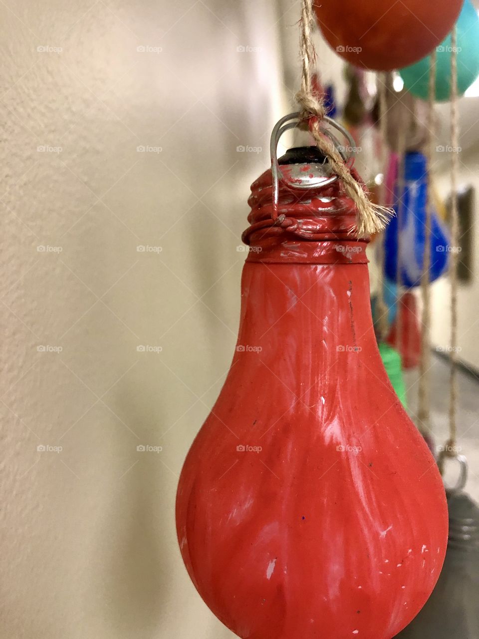Closeup foreground focus on painted red light bulb in arts and crafts project 