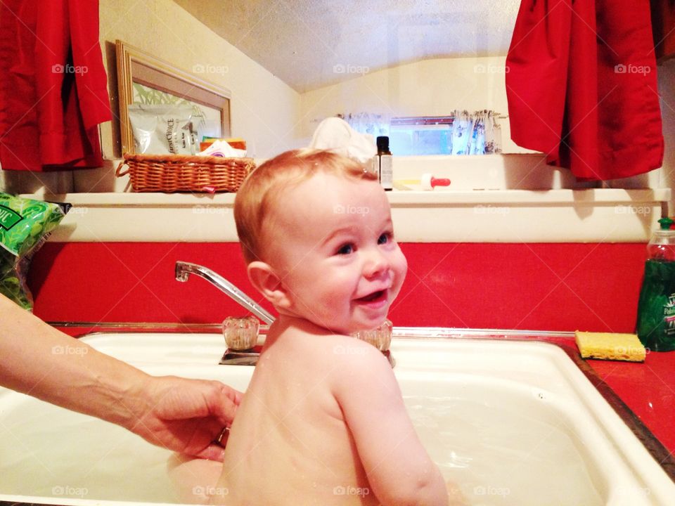 Bath time. Baby bath in kitchen sink 