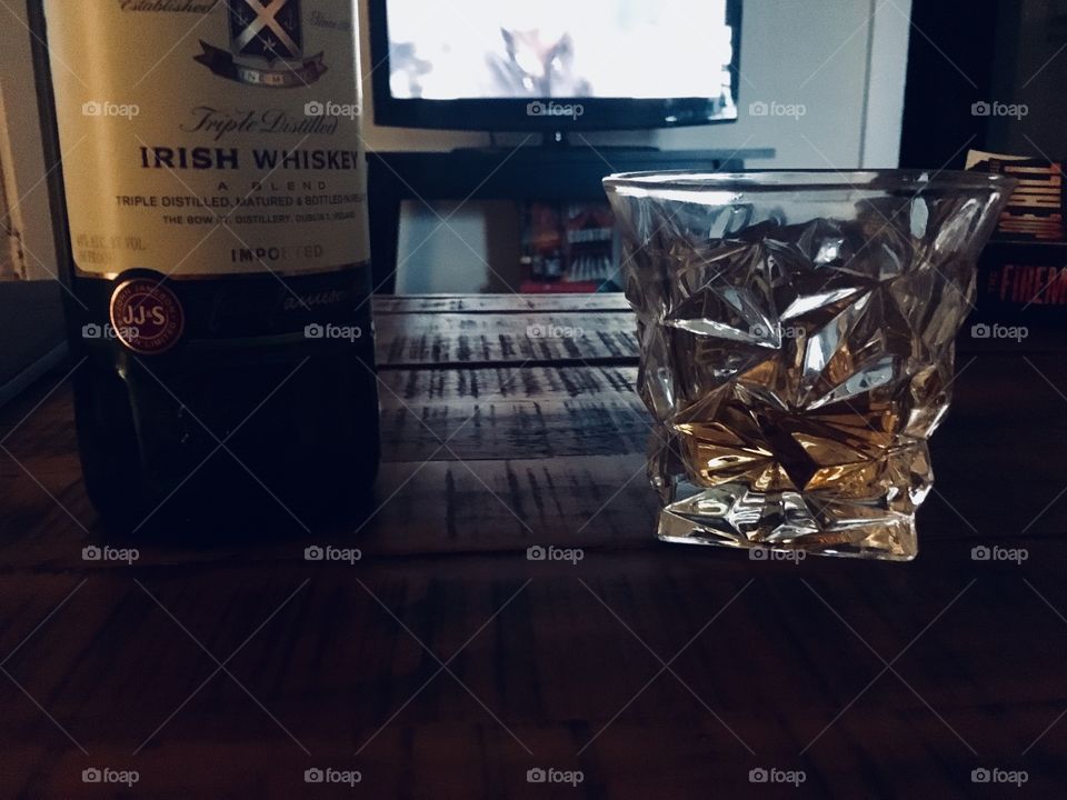 Quality Irish whiskey in a tumbler on a dark pine wooden table 