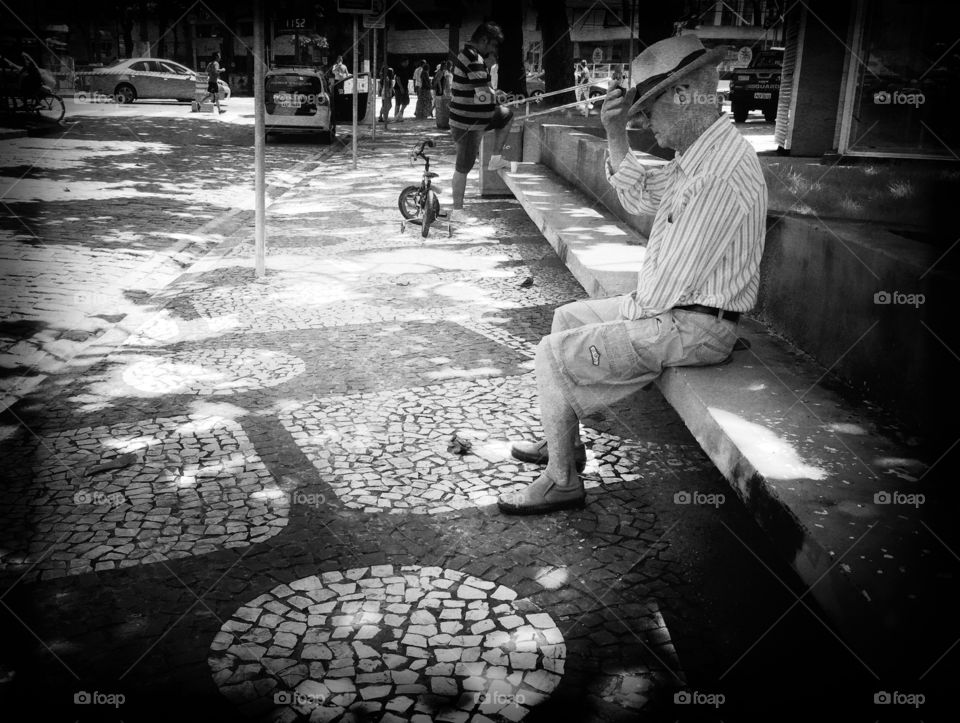 Old man with straw hat sitting thinking about life