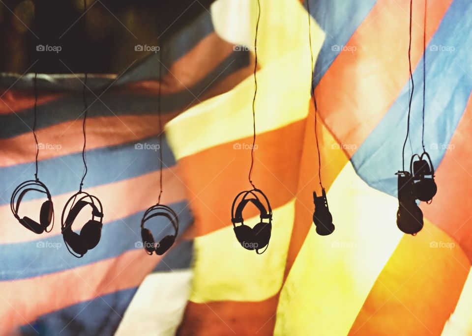 dandling headphones in front of light box with colors of Barcelona 