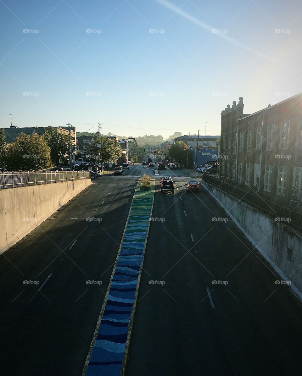 Beautiful sunrise over a busy street in a college town in the early morning. People on their way to work on a sunny day 