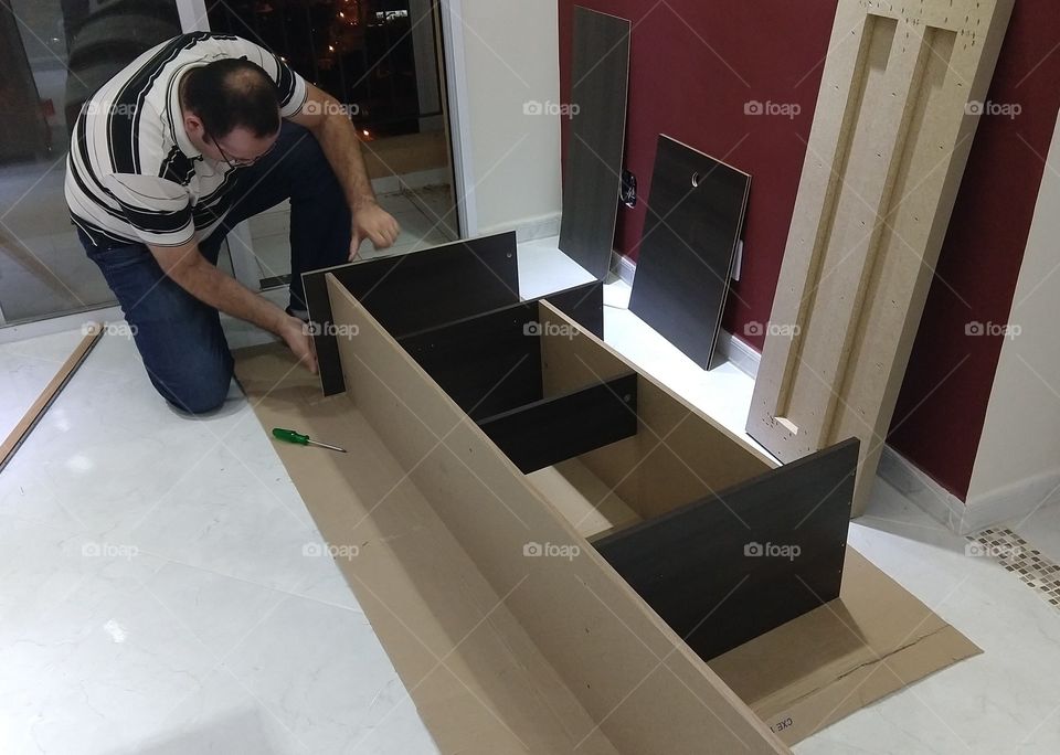 man building up furniture