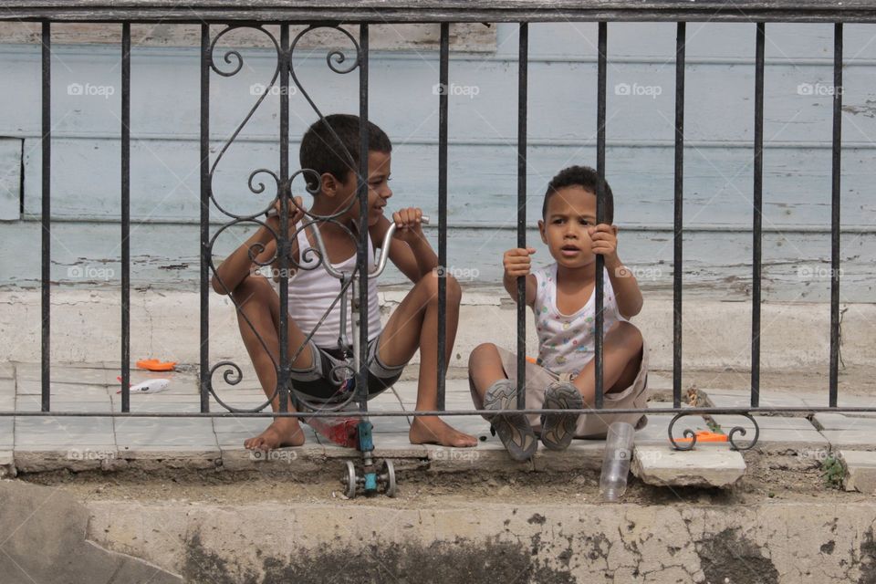 Two indian boy sitting near the railing