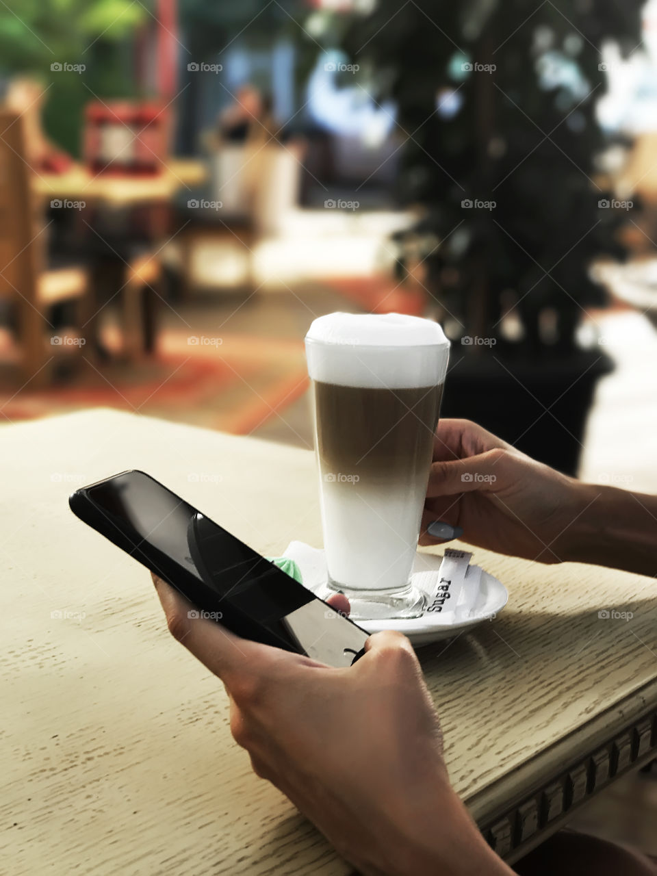 Drinking coffee and using mobile phone 