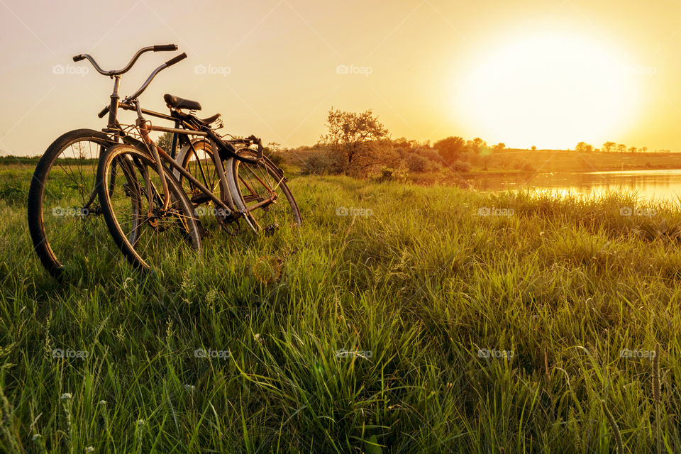 Two bike near the lake sunset background. Two vintage bicycles at sunset. The concept of romance and love