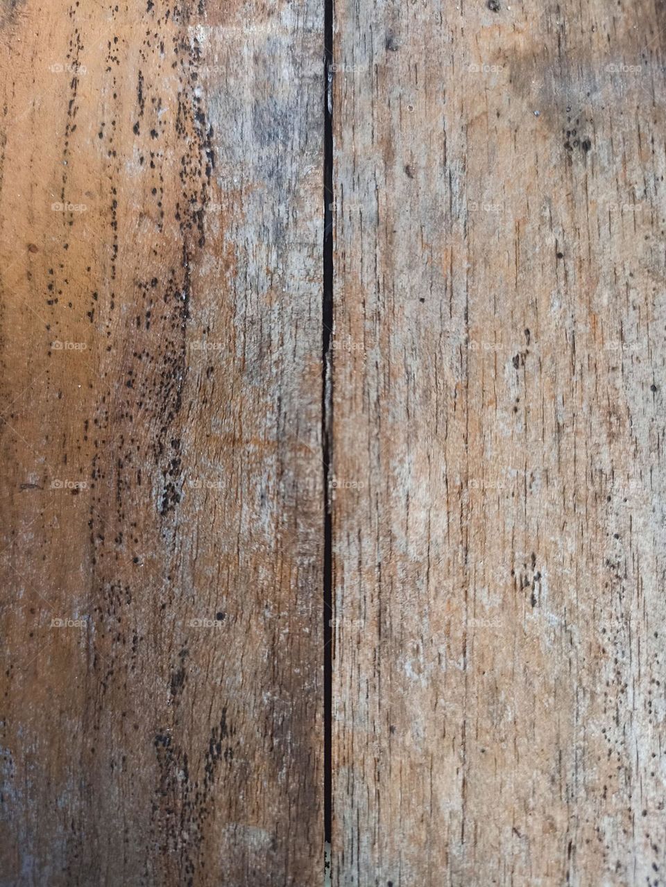 Close-up of old and worn wood texture. The wood has a light brown color with clearly visible wood grain