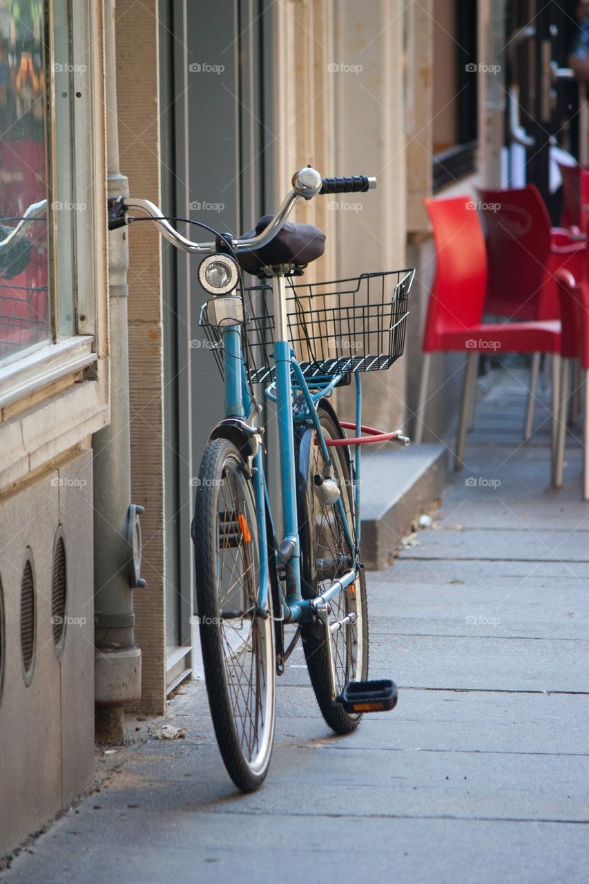 Basket bicycle leaning on wall