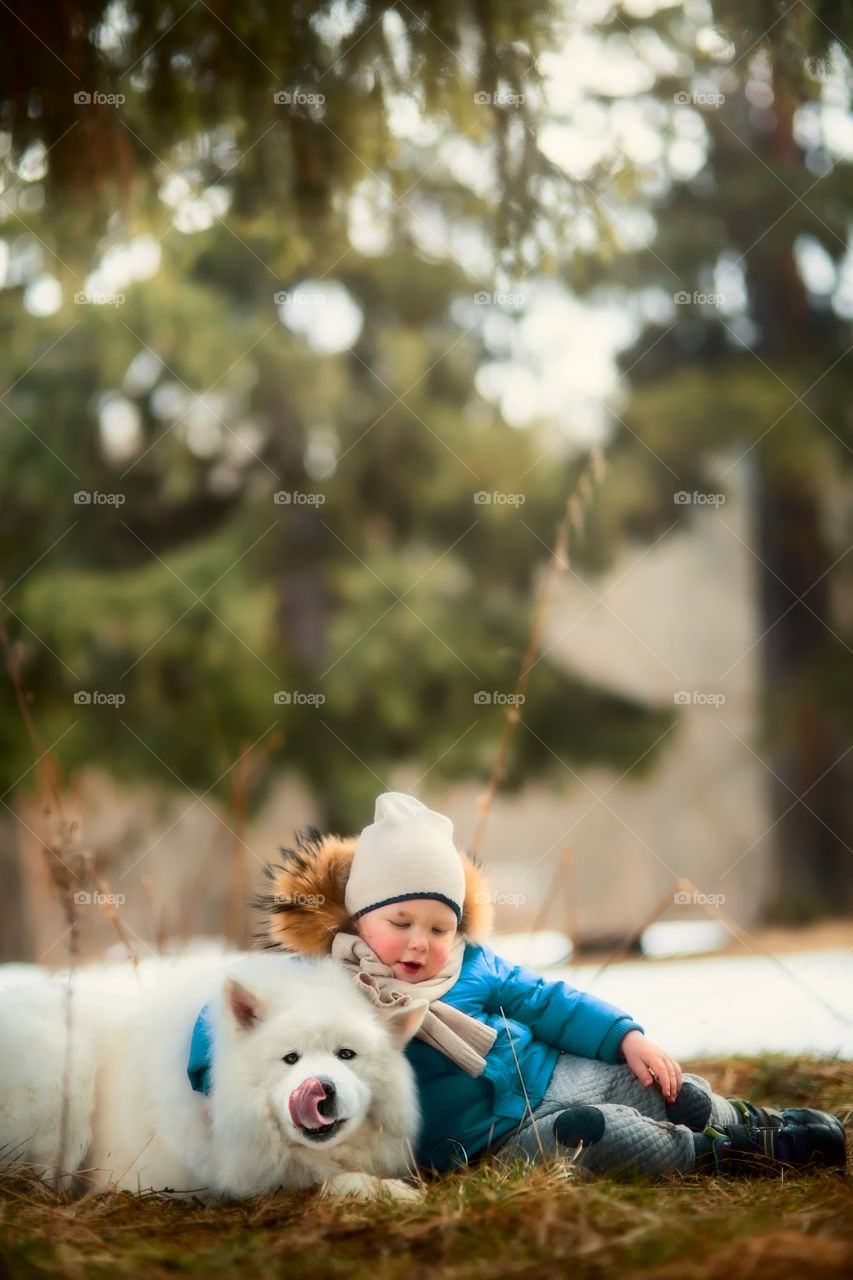 Boy with his Samoyed dog in winter park