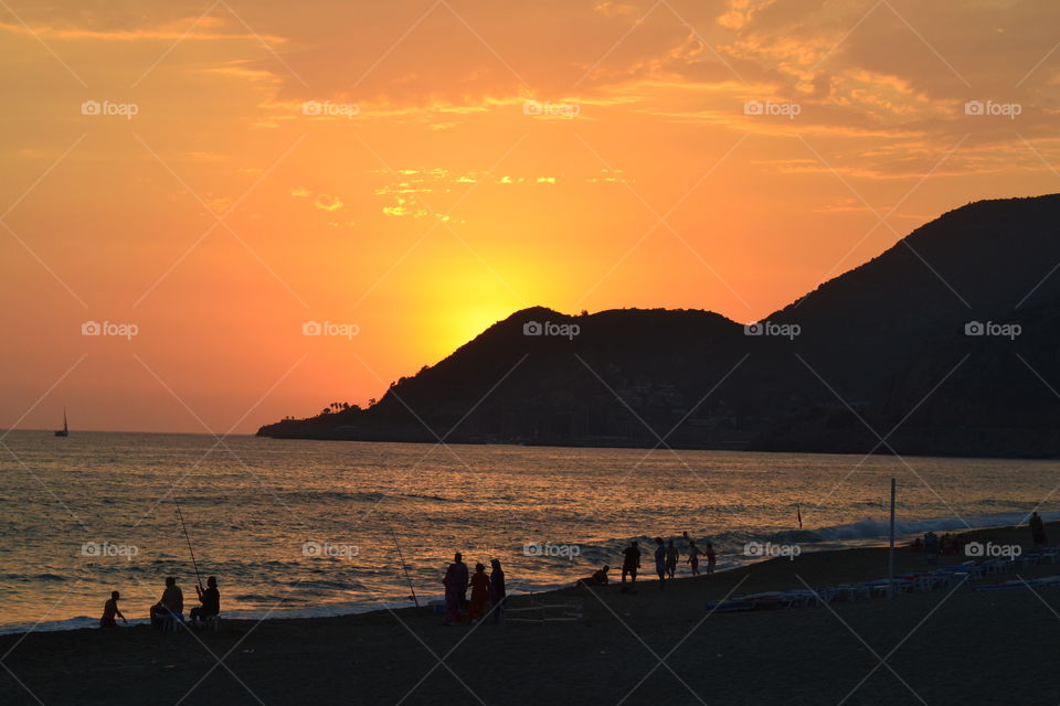 sunsetting over fishermen on the beach