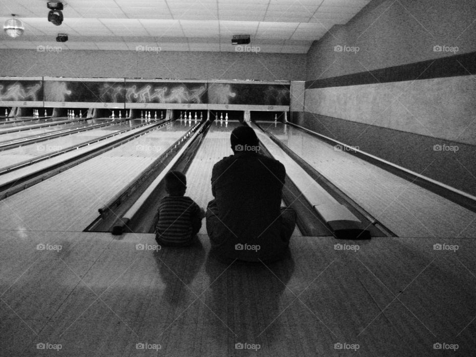 Father and son figuring out bowling strategies 