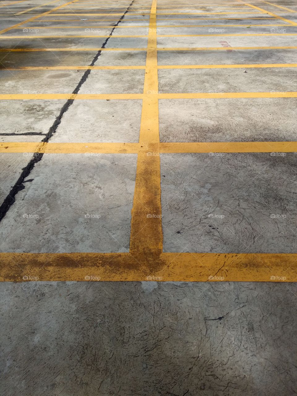 Full frame shot of parking lot. Full frame shot of street with yellow marking.