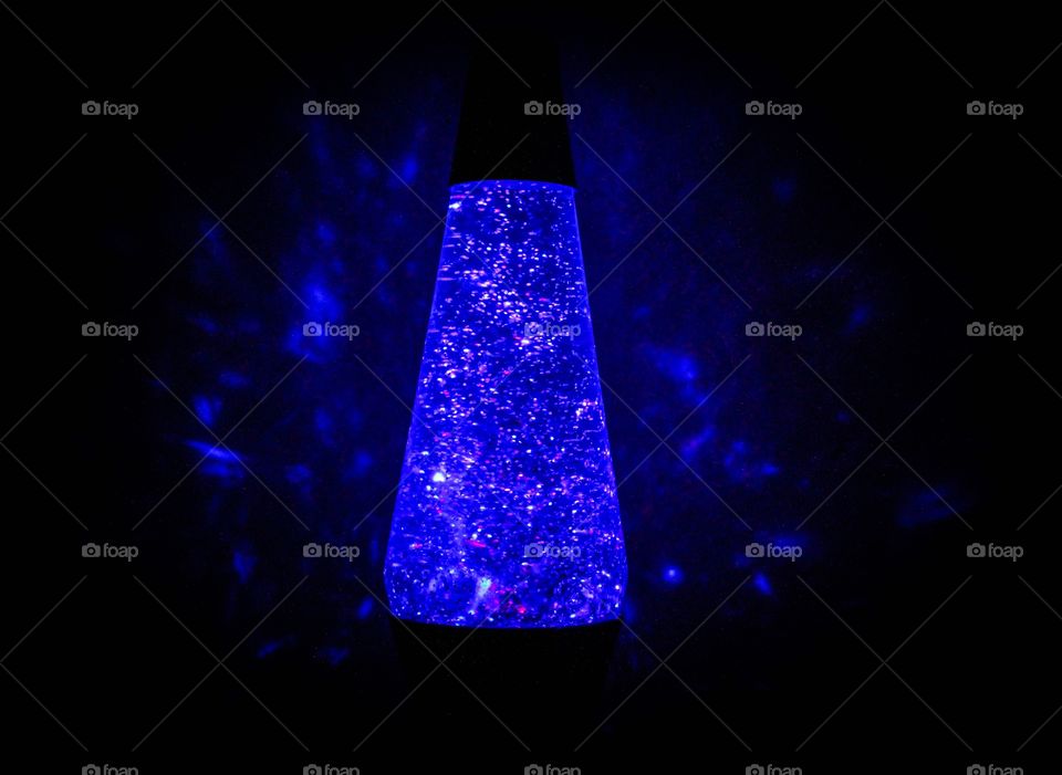 A vortex lamp that is colored blue and put in the dark to show beautiful reflected light. 