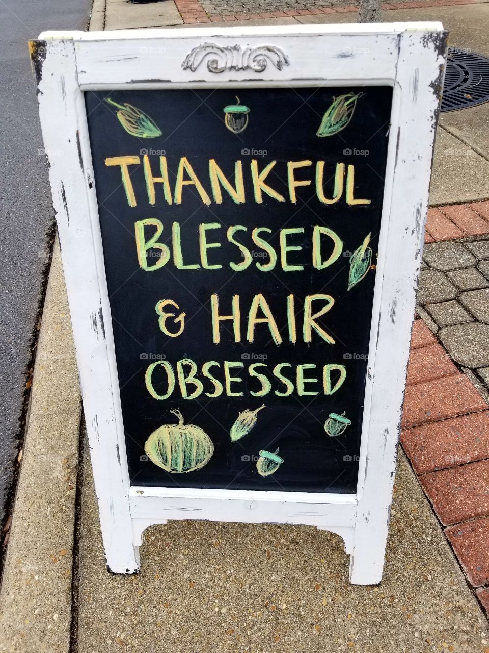 Cute sign on sidewalk outside a hair salon