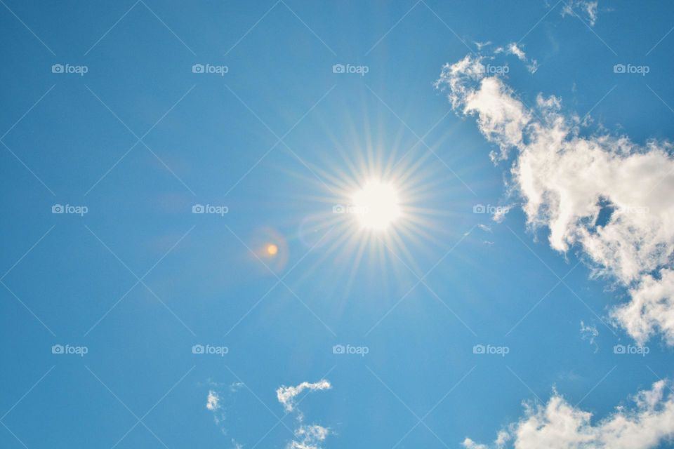 Summer sky view with sun and clouds