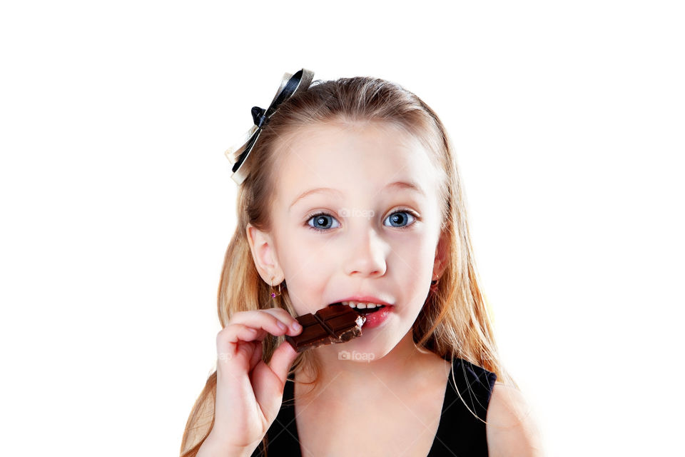 Cute blond girl eating chocolate