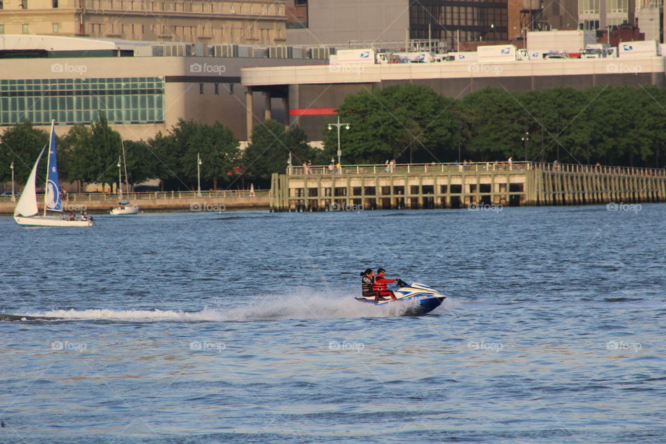 Jet-ski on Hudson River with sailboat in background 