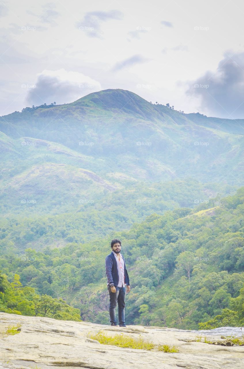 Man standing in front mountain in forest