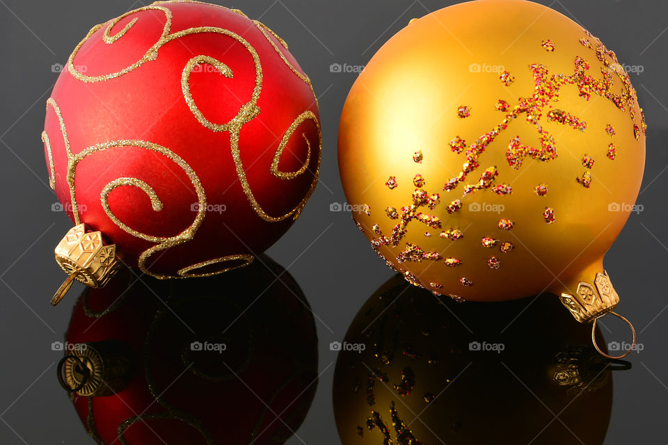 Toys on the Christmas tree lie on a reflective surface. The concept of the holiday is Christmas or New Year