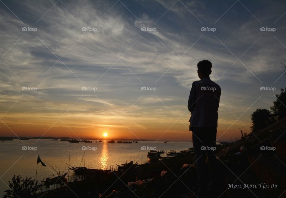 Gazing the rising sun at Irrawaddy river bank