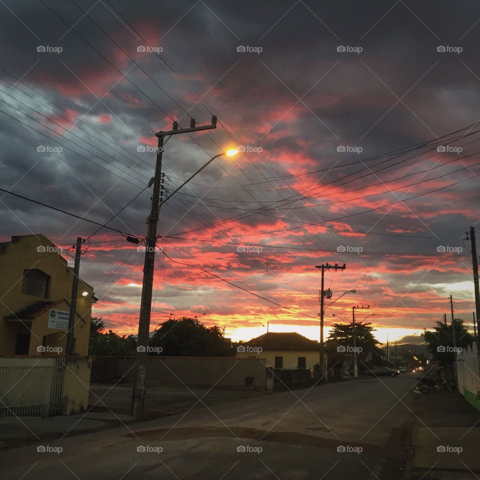 Road amidst building in city during sunset