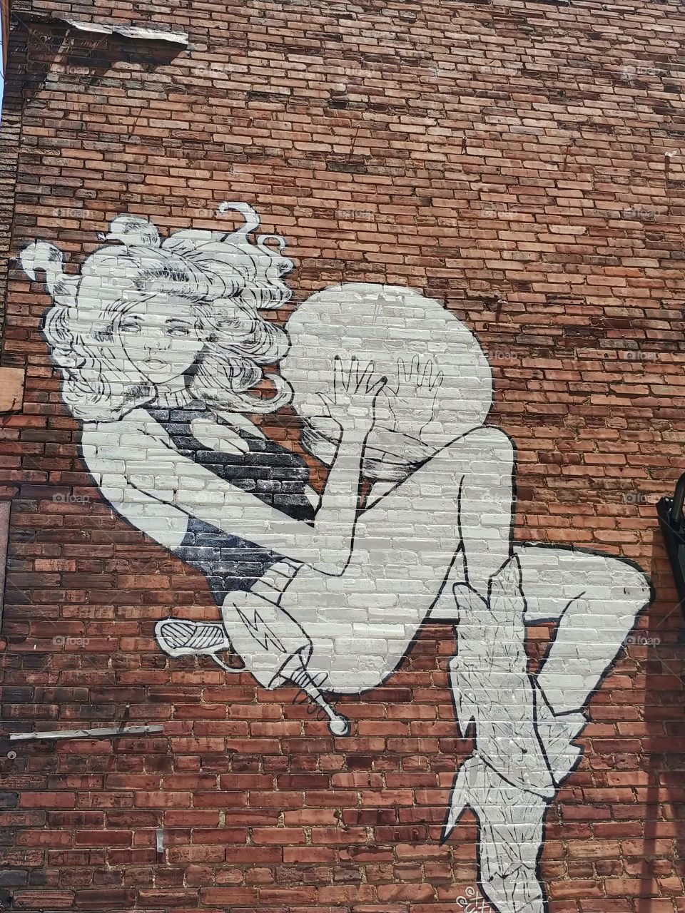 A wall mural of a space woman painted on a wall in downtown Louisville Kentucky