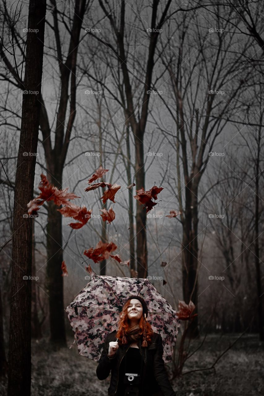 Young woman holding umbrella in autumn season