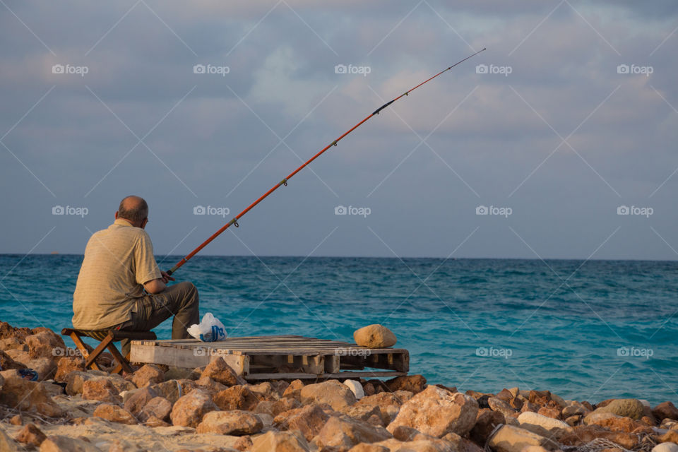 A man fishing by the sea