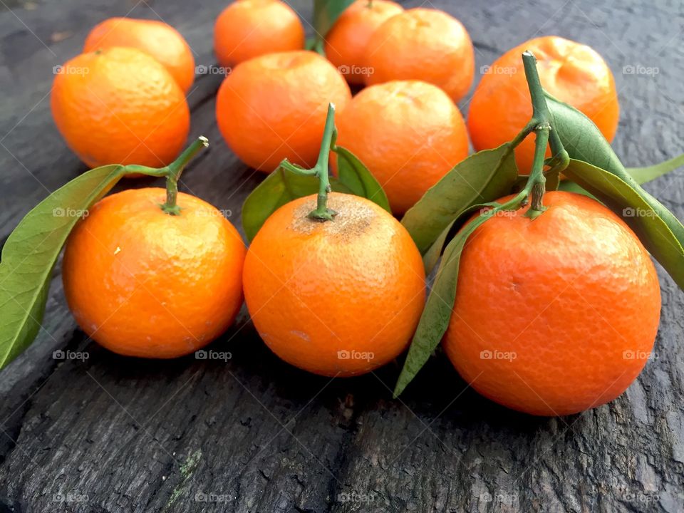 Mandarines with leaves on wooden table