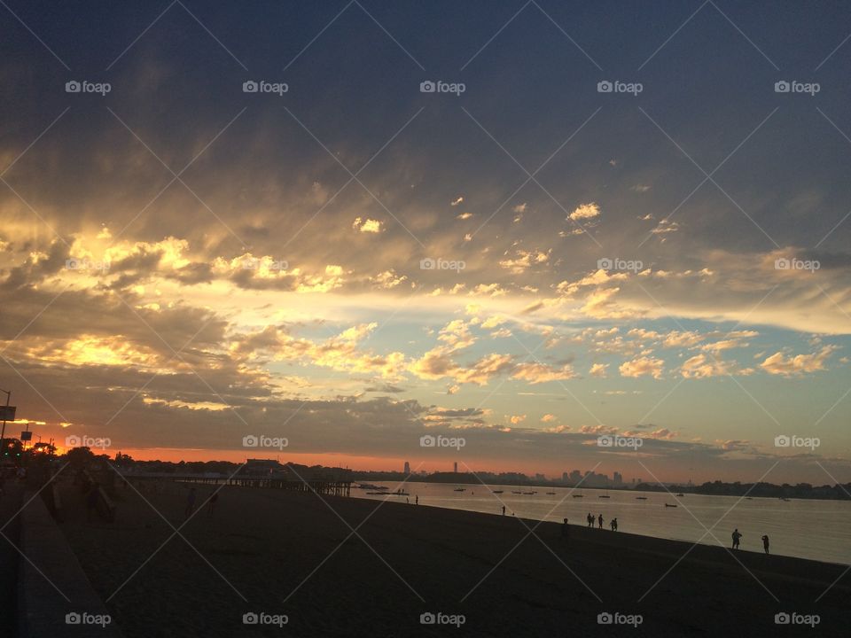 Beach city sunset. Sunset with cloud layers over Quincy, MA with Boston in background