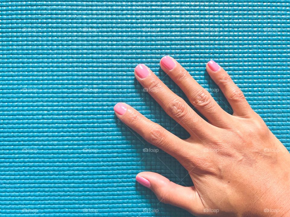 A hand on a light blue mat