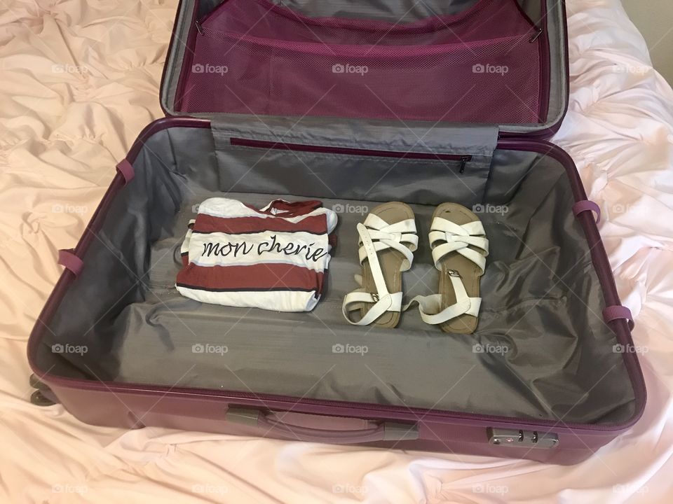 Travel for the holidays - a suitcase with saltwater sandals and a t shirt that reads mon Cherie
